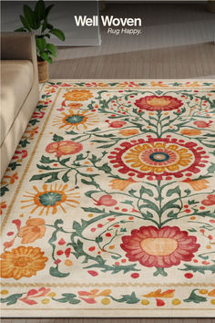 a large rug with flowers on it in the middle of a living room, next to a couch