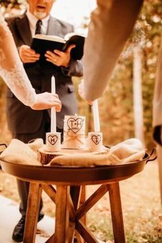 a bride and groom are getting ready to cut their wedding cake at the alter with candles in front of them