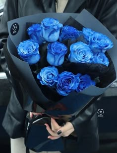 a woman holding a bouquet of blue roses