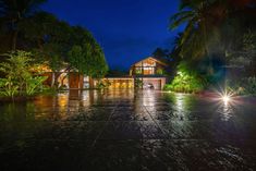 a house is lit up at night in the rain