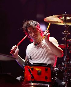 a man with red hair playing drums on stage