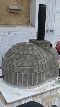 a man working on a large brick structure in the process of being made into a house