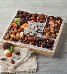 a wooden box filled with assorted chocolates and nuts