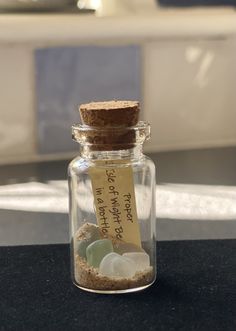 a glass jar filled with rocks and sand