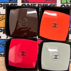 four different colored plates sitting on top of a wooden table next to a colorful wall