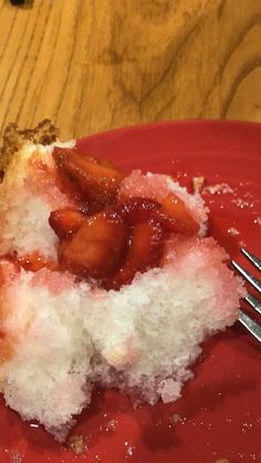 a piece of cake that is on a red plate with a fork next to it