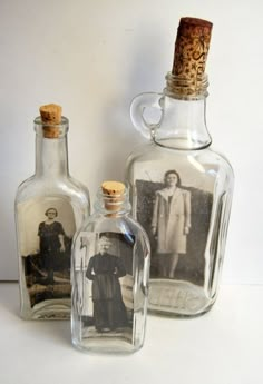 two empty glass bottles with pictures in them