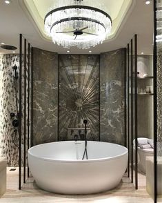 a large white bath tub sitting inside of a bathroom next to a chandelier