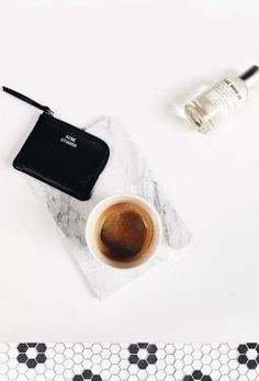 a white table topped with a laptop computer next to a cup of coffee