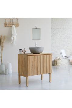 a bathroom with a sink, mirror and towels on the rack next to white chairs