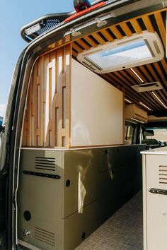 the back end of a van with an open roof and storage compartment on it's side