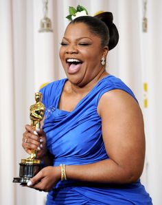 a woman holding an oscar award with a child