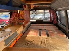 the interior of an old camper van with beds and curtains on it's sides