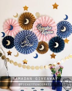 the ramadan giveaway is on display in front of a wall with paper fan decorations