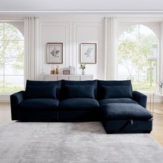 a large blue sectional sofa in a living room with white walls and wooden flooring