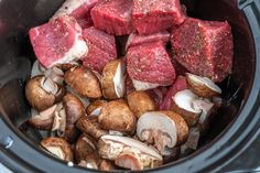 raw meat and mushrooms are in the slow cooker