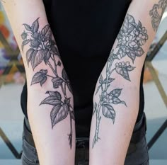 a woman's arm with flowers and leaves on it