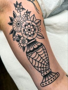 a black and white tattoo with flowers on it