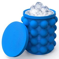 a blue container filled with lots of ice next to a round object on a white surface