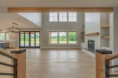 an empty living room with wood flooring and open doors leading to the front door