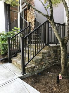 a tree that is sitting next to a set of stairs in front of a house