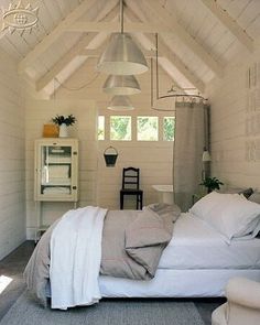 a bedroom with white walls and vaulted ceiling