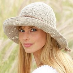 a woman with long blonde hair wearing a white hat