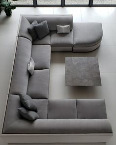 a modern living room with grey couches and white tile flooring in front of a large window