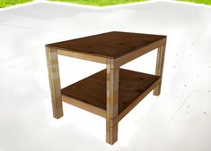 a small wooden table sitting on top of a white cement floor next to green grass