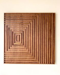 a wooden wall hanging on the side of a white wall