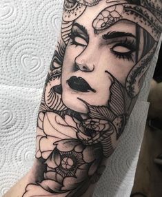 a woman's face with flowers on her arm