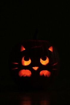 a carved pumpkin with glowing eyes in the dark