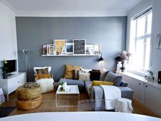 a living room filled with furniture and pictures on the wall