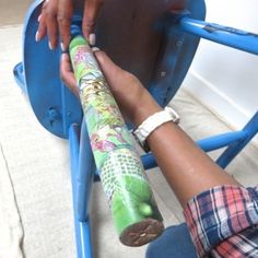 a person sitting in a blue chair with a colorful umbrella on it's leg