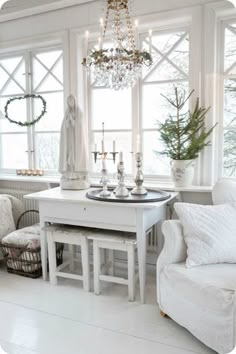 a living room filled with furniture and a chandelier hanging from the ceiling next to a window