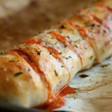 a piece of bread with sauce and herbs on it