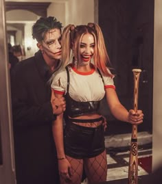 two people dressed up as the joker and harley in a hallway with a mirror behind them