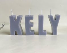 three candles that spell out the word kelly