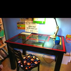 a desk with a chair and a lamp on it in a room filled with children's books