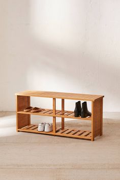 two pairs of shoes sitting on top of a wooden shelf next to a white wall