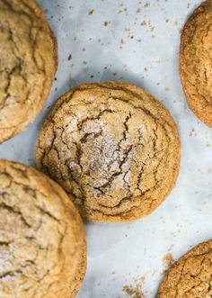 several cookies on a white surface with some powdered sugar