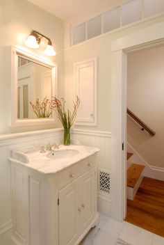 a bathroom with a sink, mirror and stairs