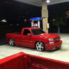 a red truck parked in front of a gas station