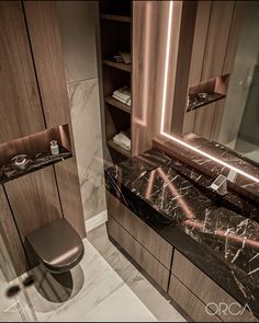 a modern bathroom with marble counter tops and wooden cabinetry, along with a toilet