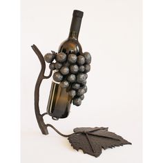 a wine bottle holder with grapes attached to it