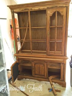 an old wooden bookcase with glass doors and rope on the front, is being worked on