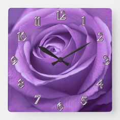 a purple rose with numbers on it is shown in this square wall clock, as well as the date and time