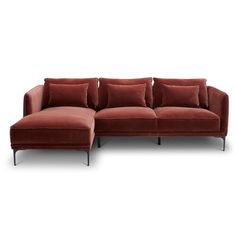 a red sectional couch with pillows on it's back and side ends, in front of a white background