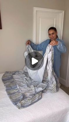 a man is holding up an unmade bed