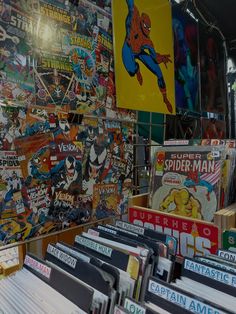 there are many comic books on display in the store front window and behind them is a wall full of comics